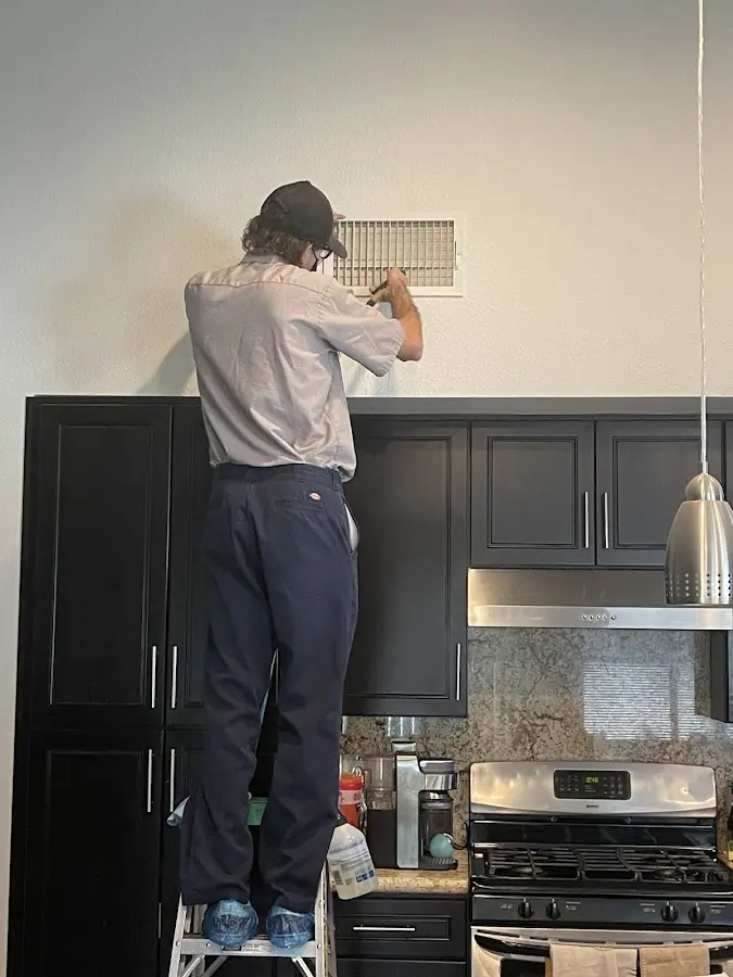 Technician inspecting an air vent during HVAC service in Topsham